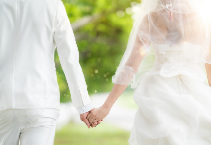 屋外で手を取り合う新郎新婦